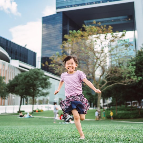 smiling girl running in green built environment