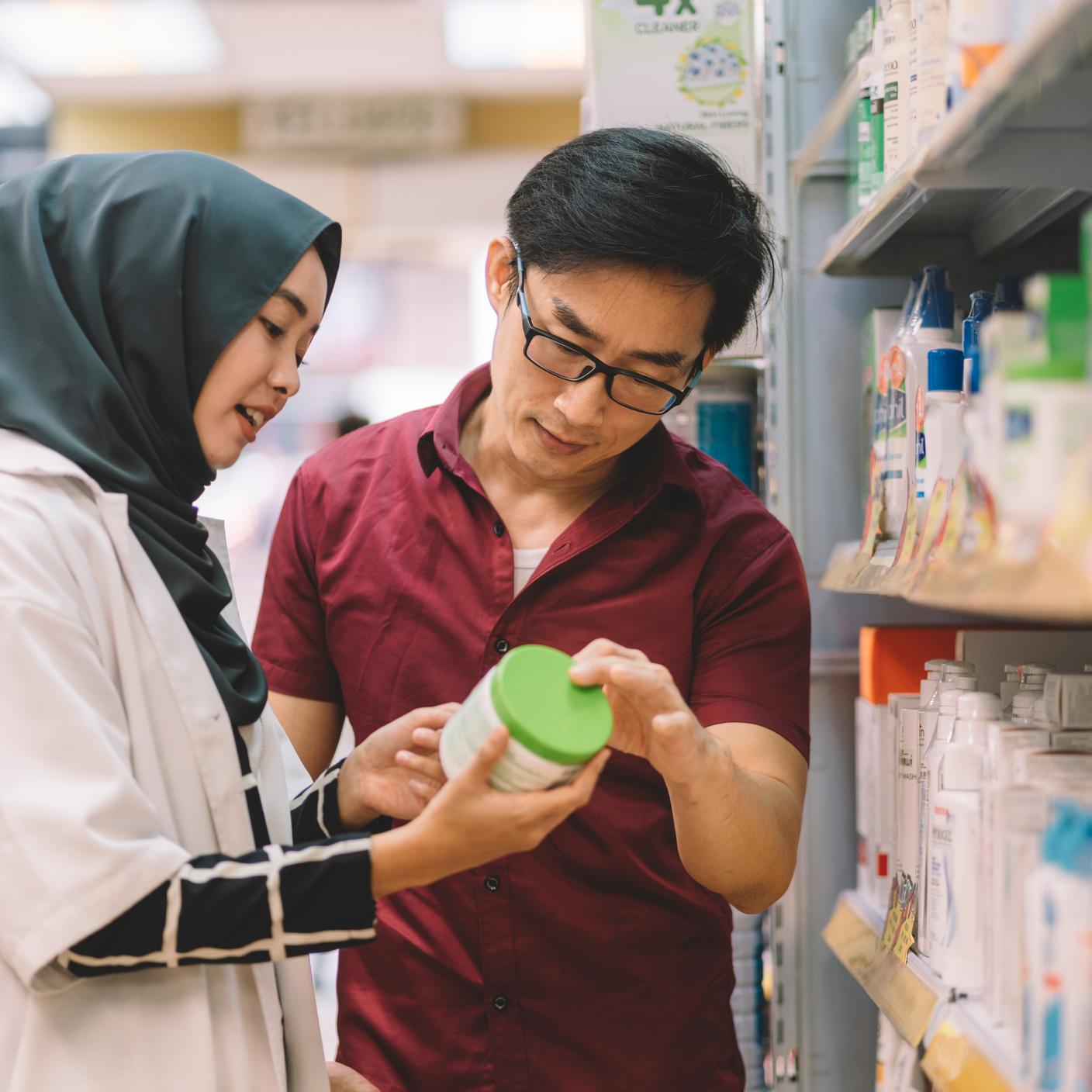 A customer with a pharmacist in a pharmacy