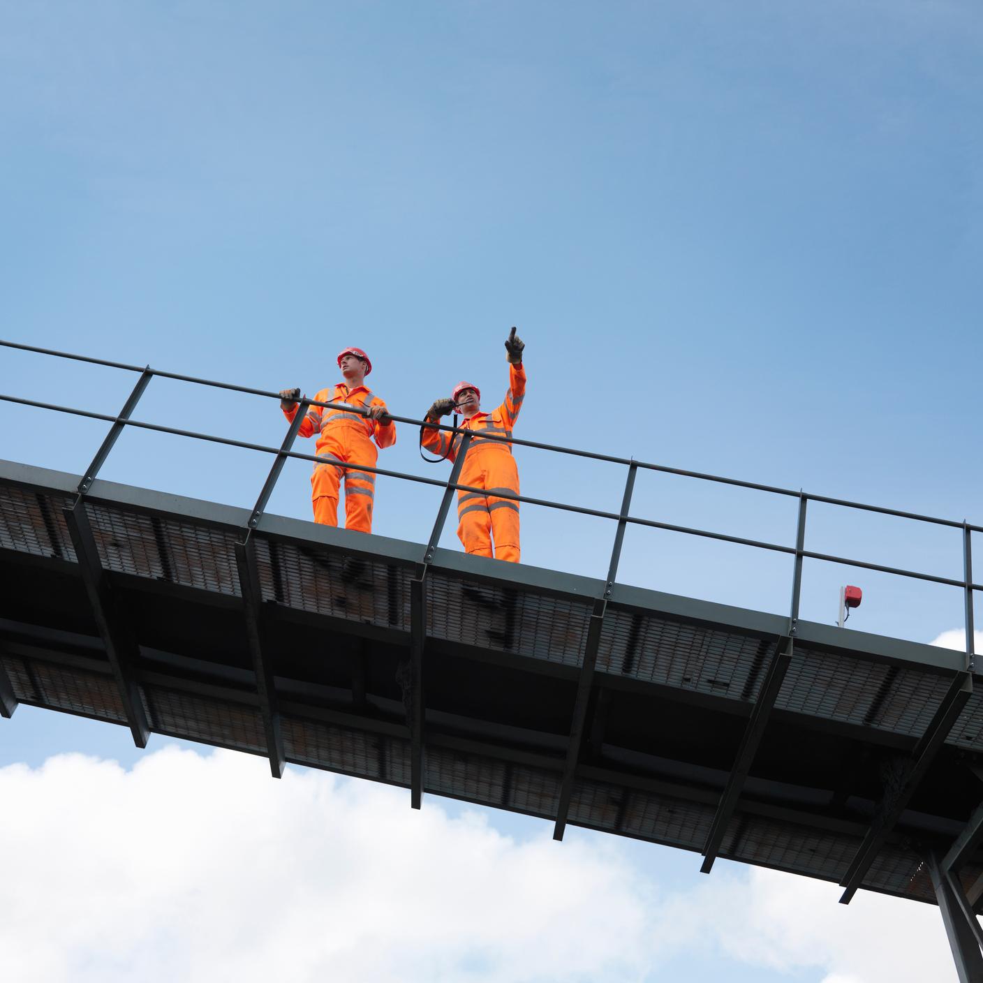 construction workers on top of rails bridge