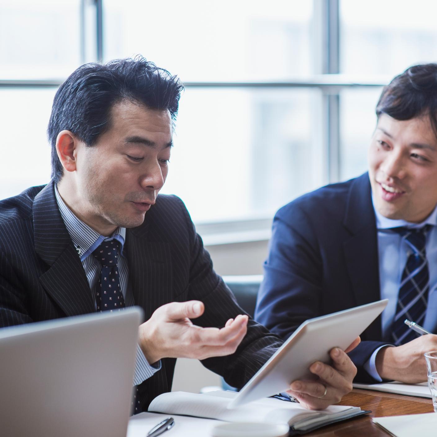 Male boss is in progress a meeting while using a digital tablet