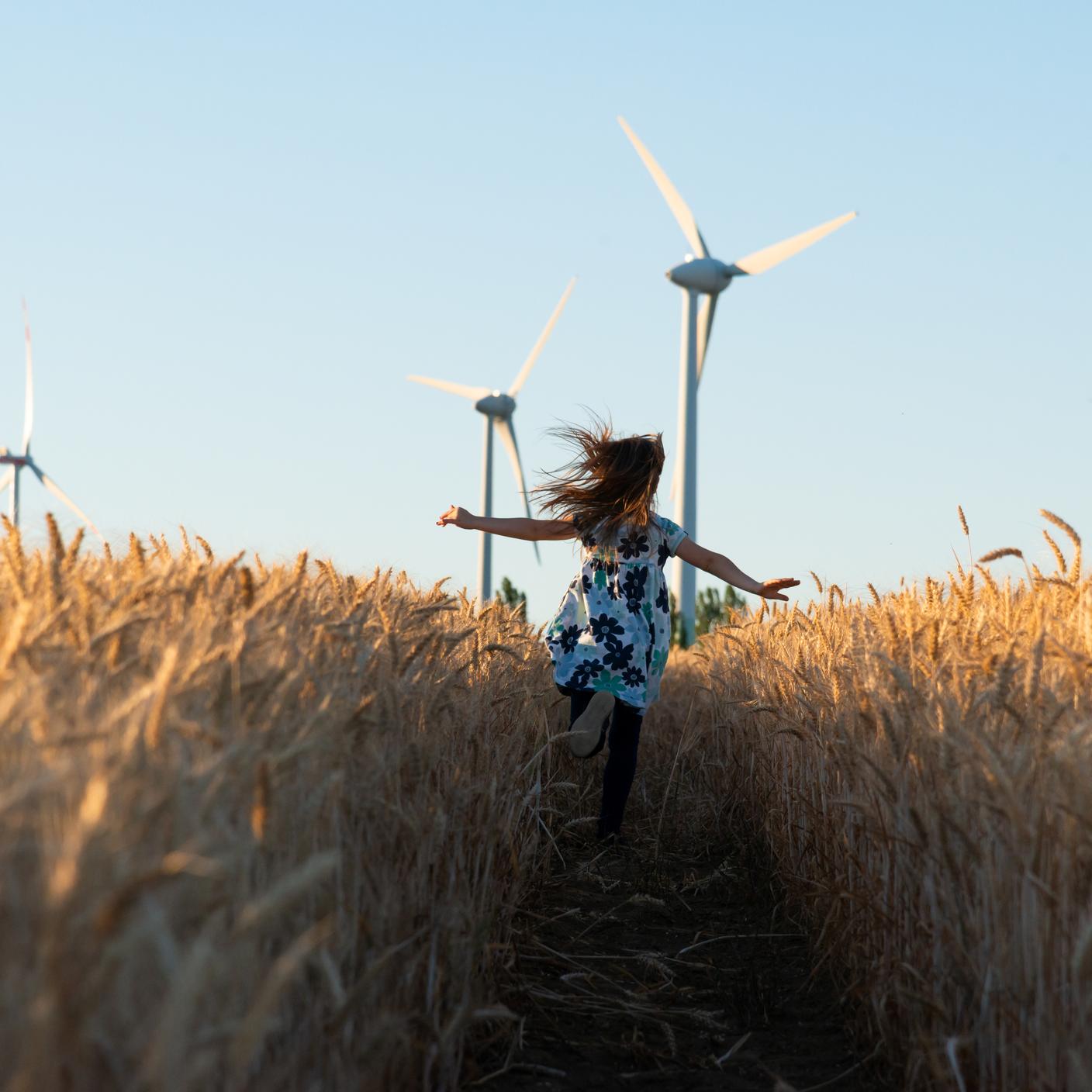 Girl is running the way to wind energy