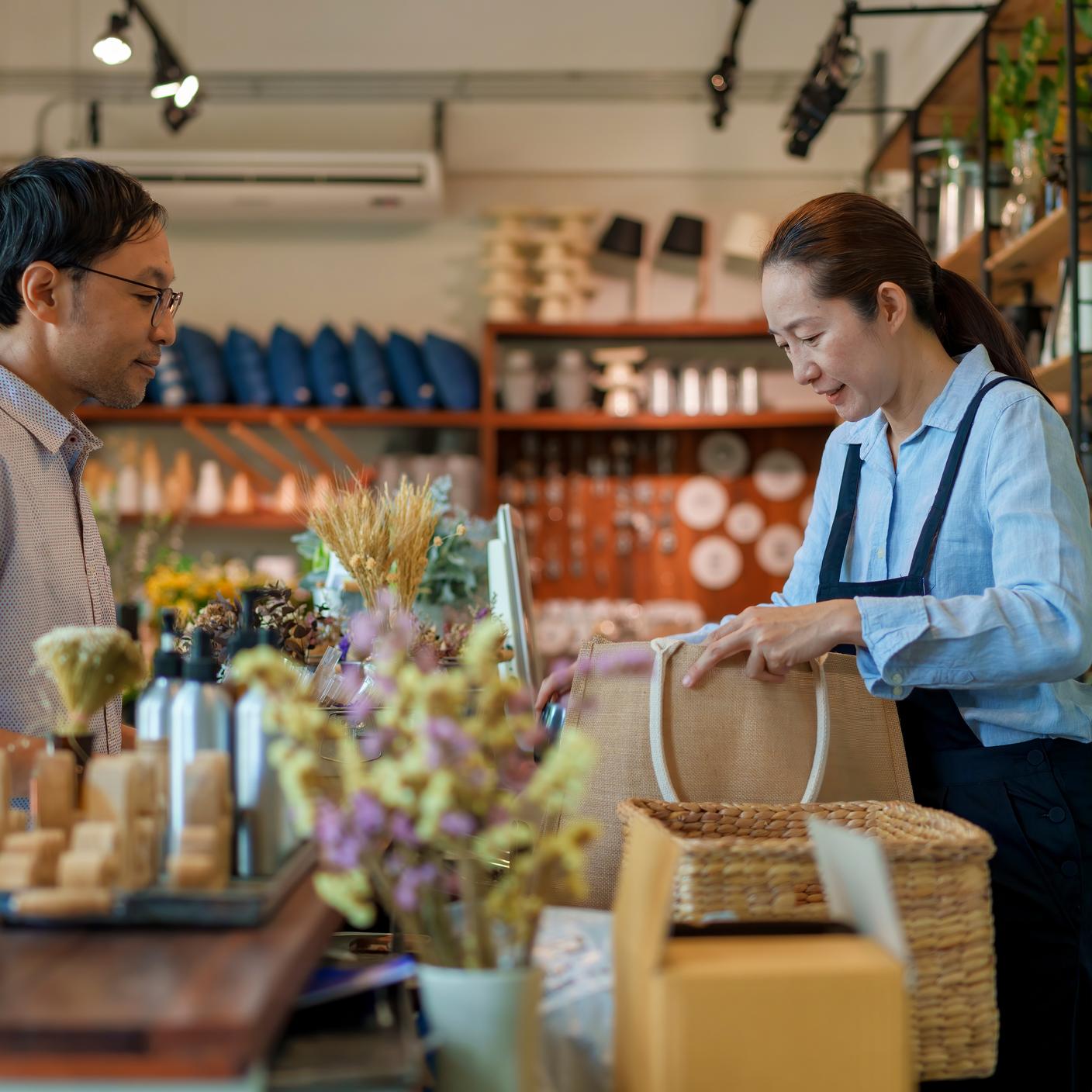 Un Japonais passe à la caisse avec le propriétaire d’un magasin de décoration d’intérieur zéro déchet.