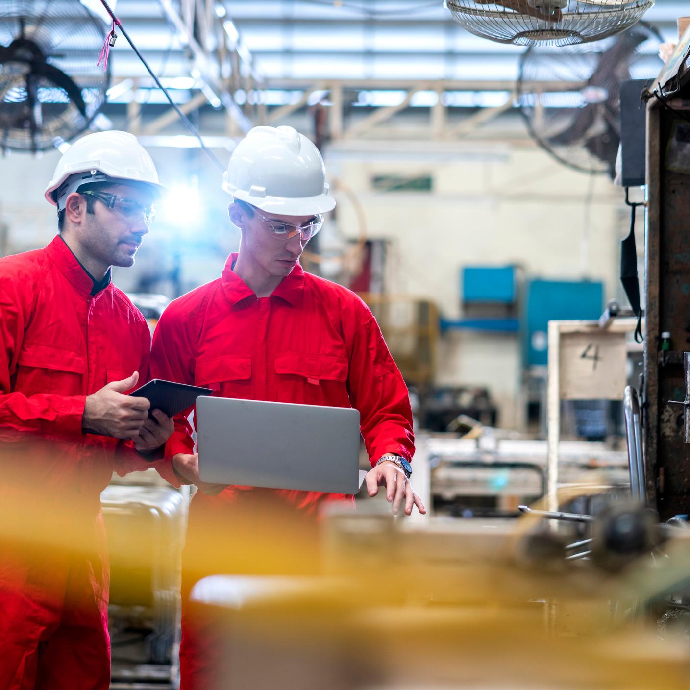 Two engineers working on a machine in a factory