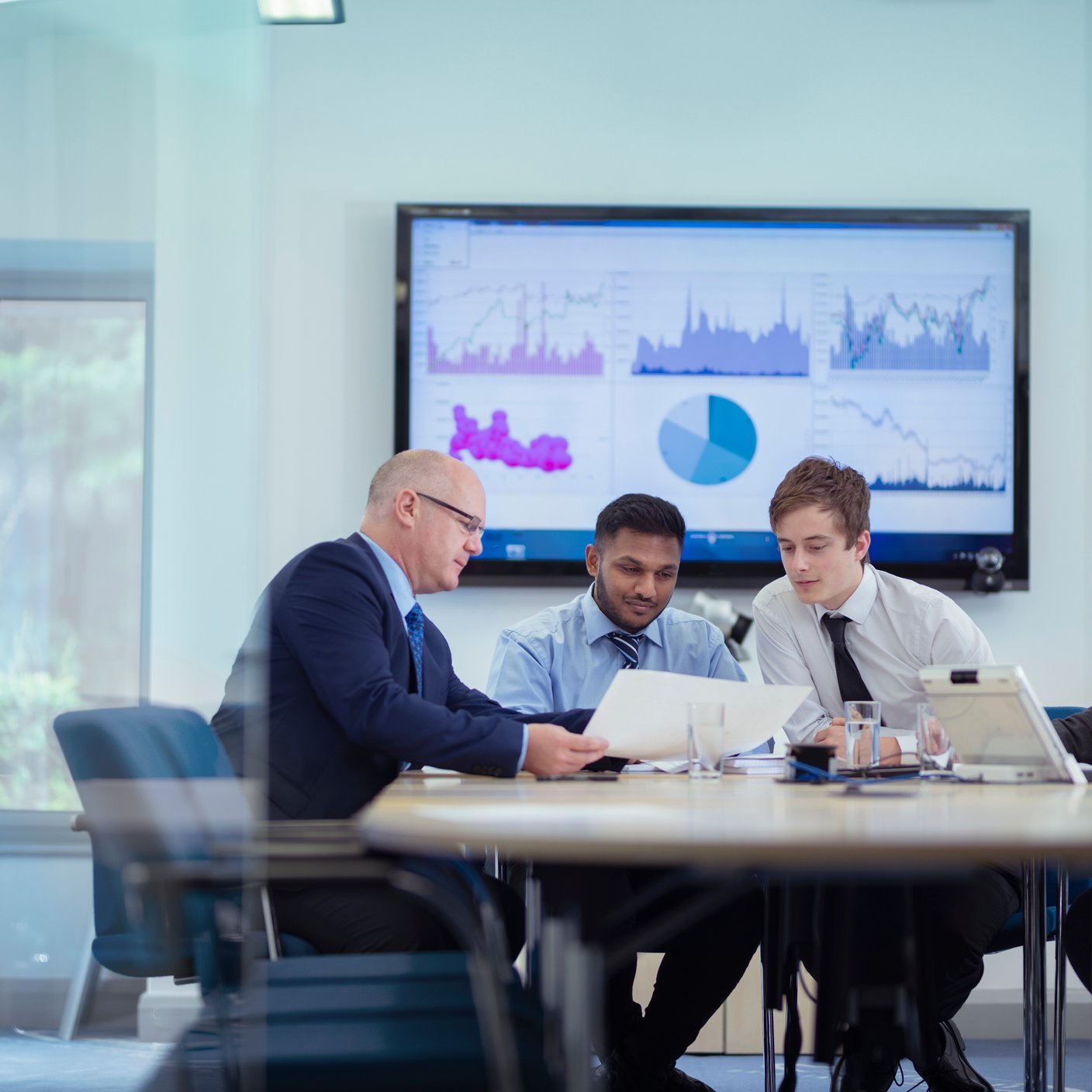 Office workers in meeting with graphs and charts