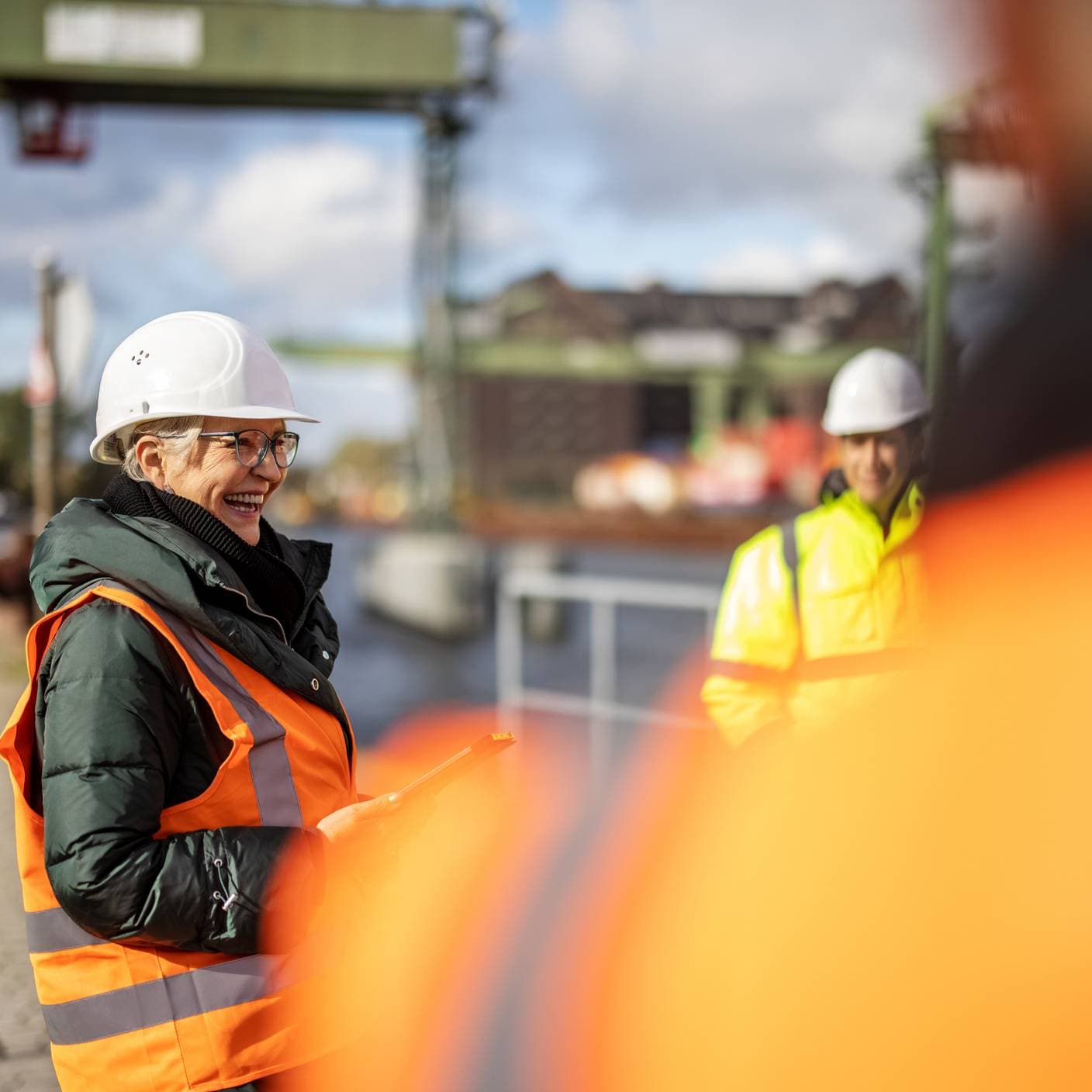 Logistics yard manager discussing cargo transportation schedule with coworkers.