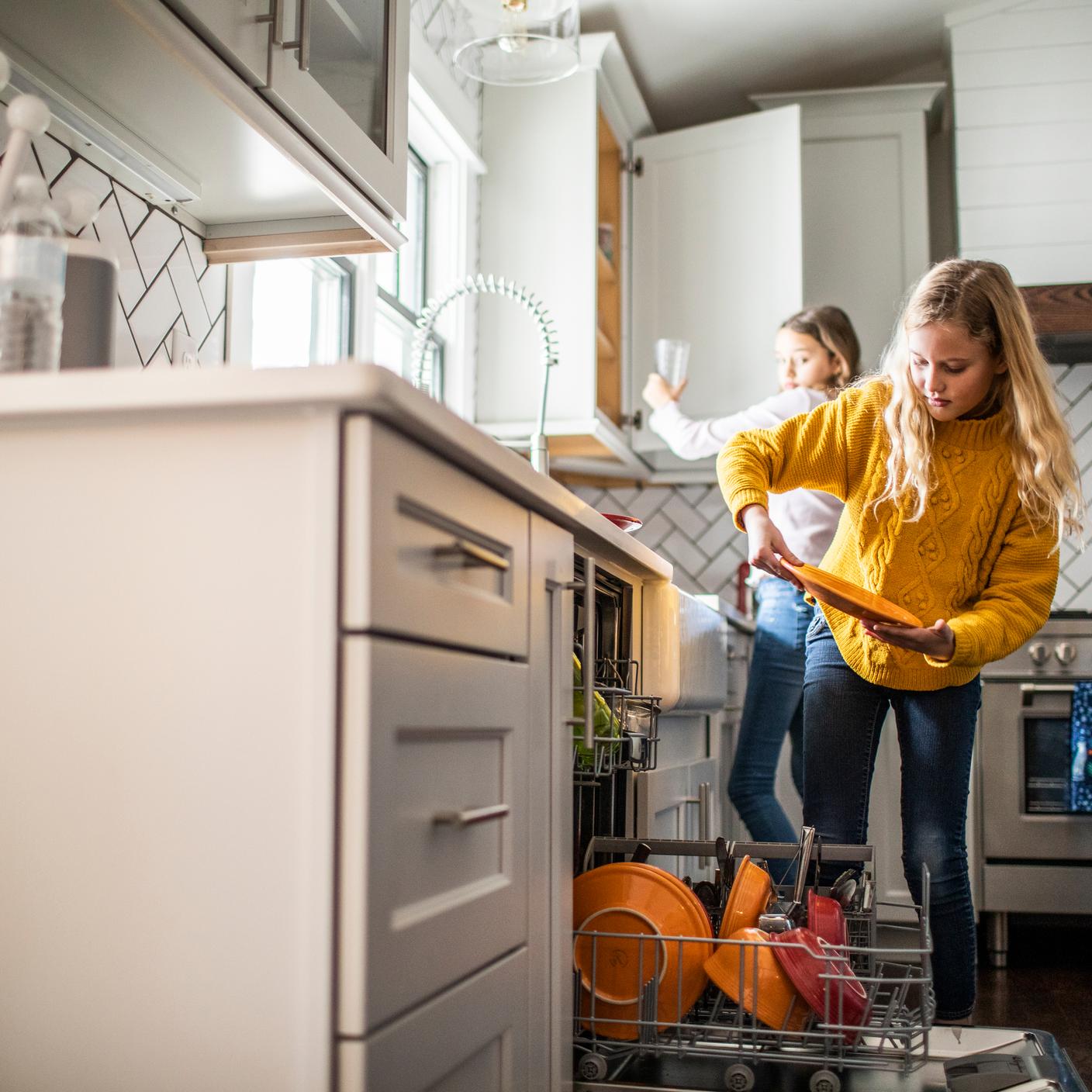 Teenage girls using a dishwasher