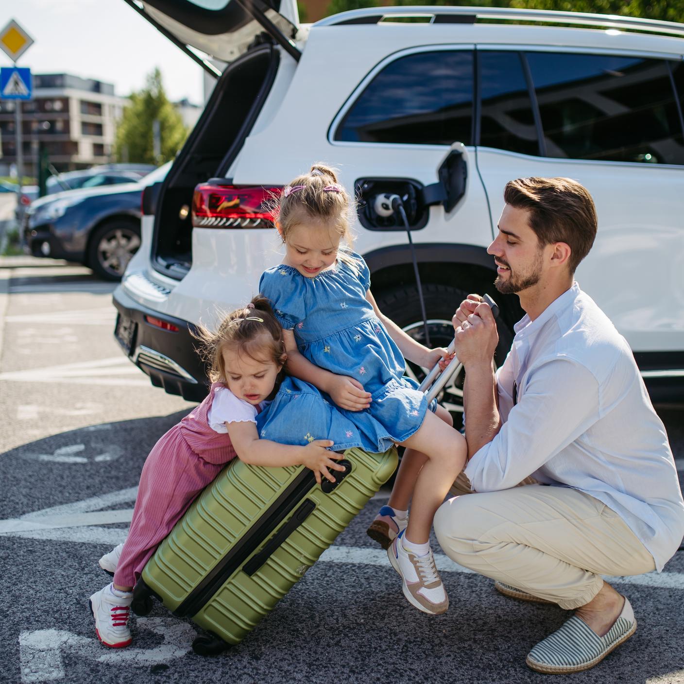 Family getting ready for a trip and waiting to charge their electric car