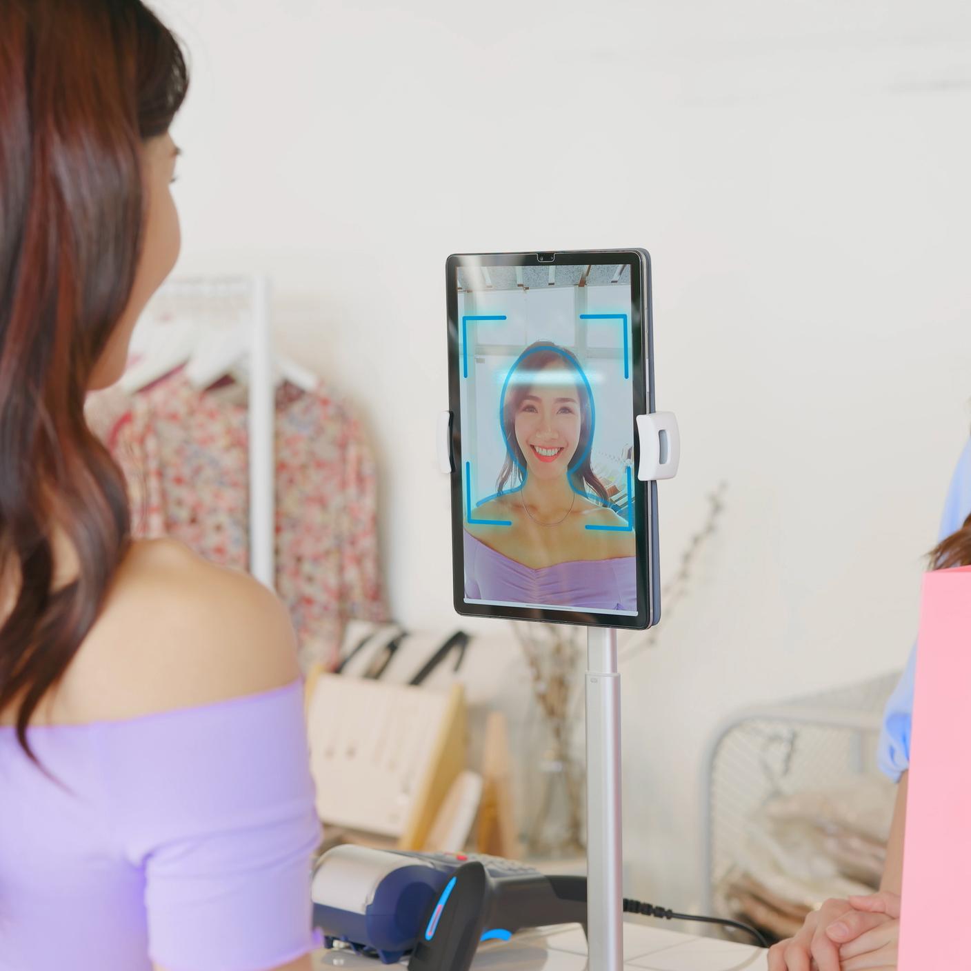 asian girl use facial identification technology to make online credit card payment during shopping in store