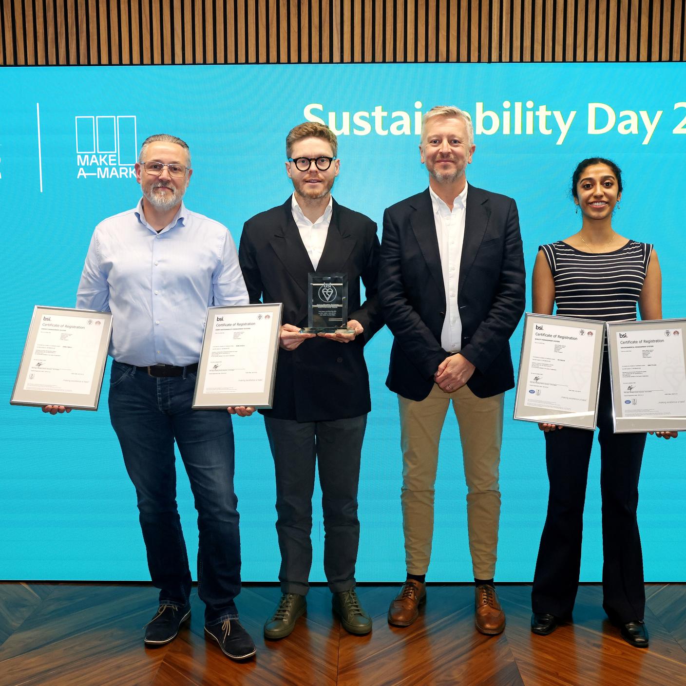 Four people holding Aston Martin Certifications