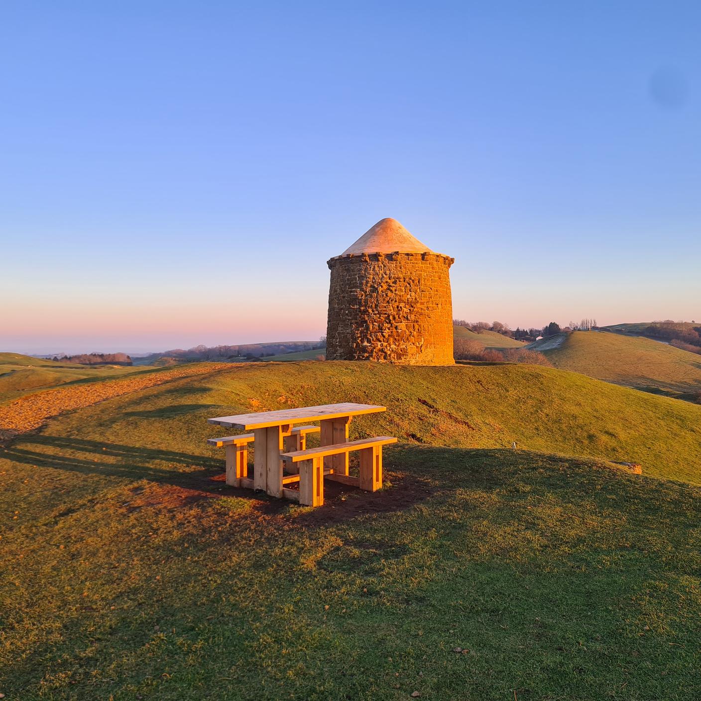 An outdoor landscape image in Warwickshire of an outdoor building and picnic bench