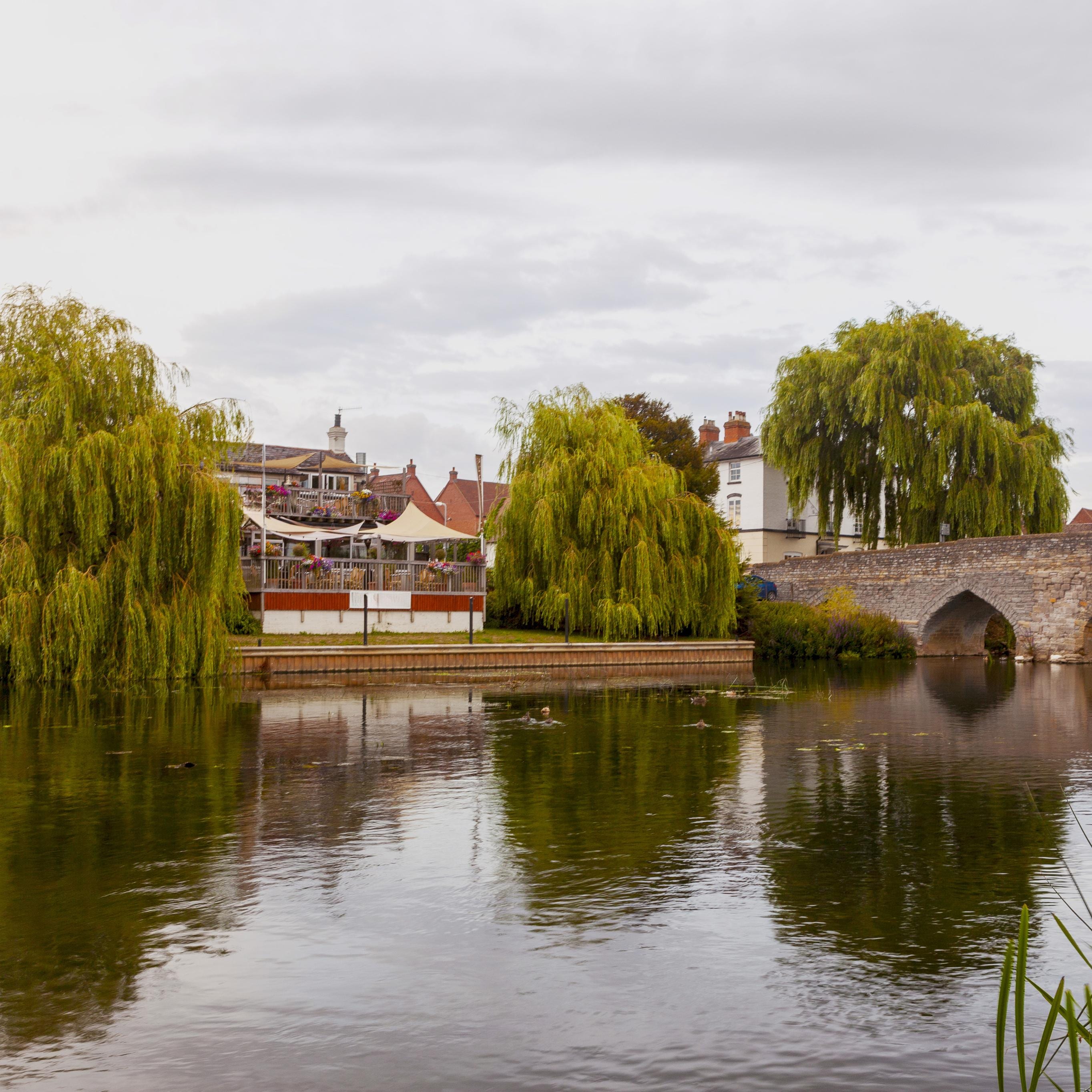 A view of a river, bridge and some buildings in Warwick.