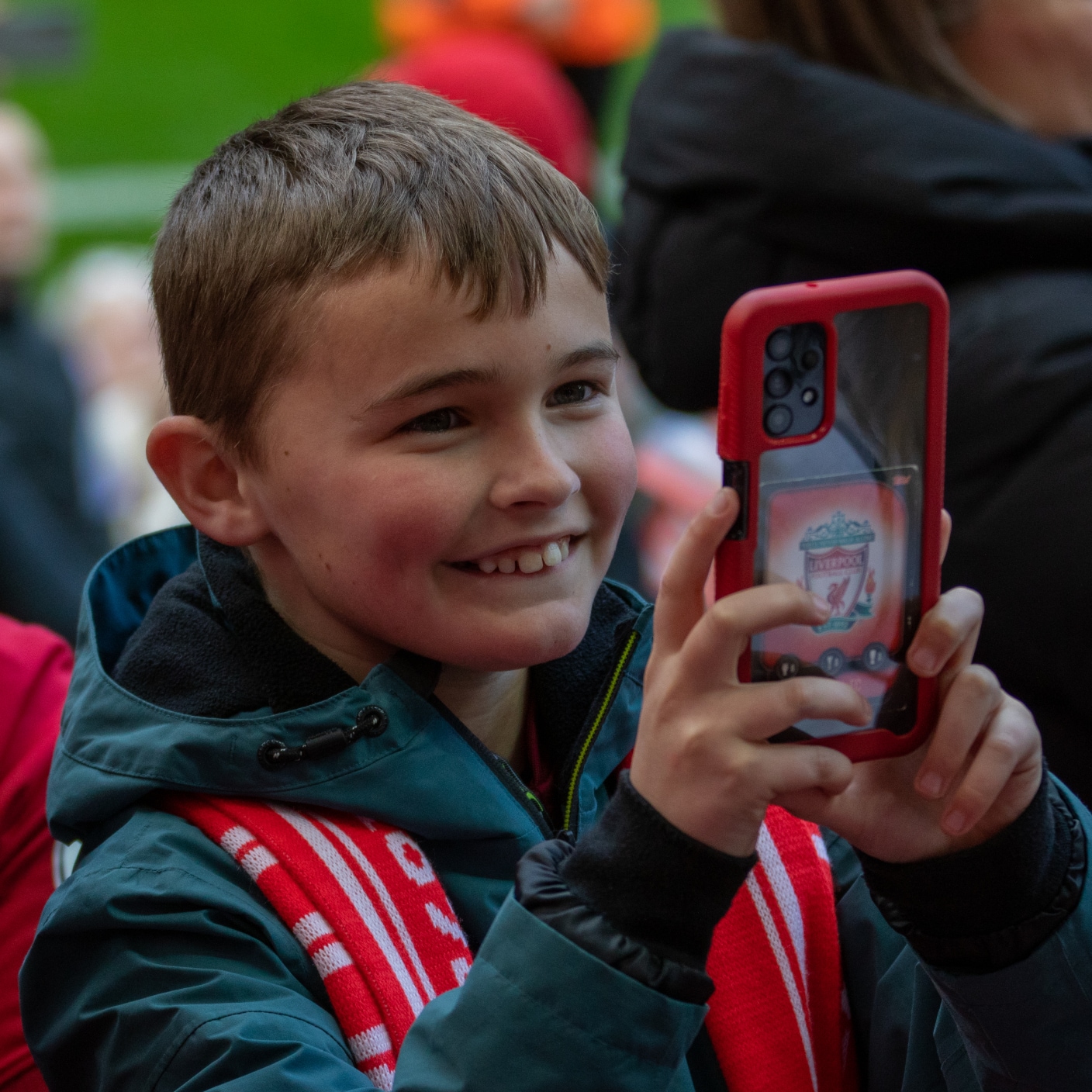 happy young fan using phone at football game