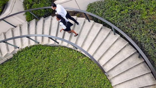 High angle view of business people ascending spiral stairway