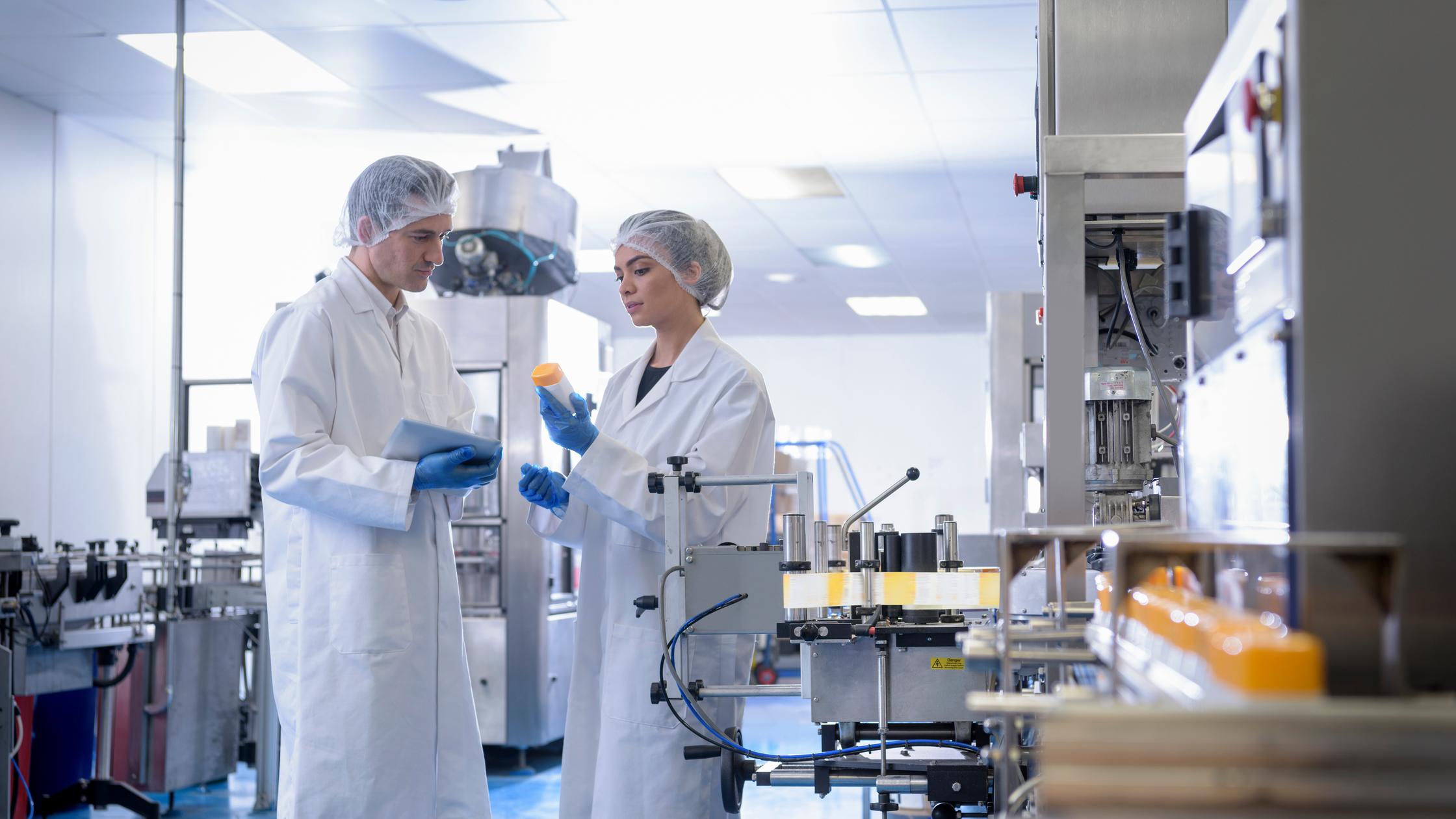 Workers inspecting product in pharmaceutical factory