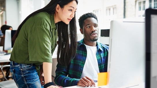 Colleagues in office looking at a computer screen