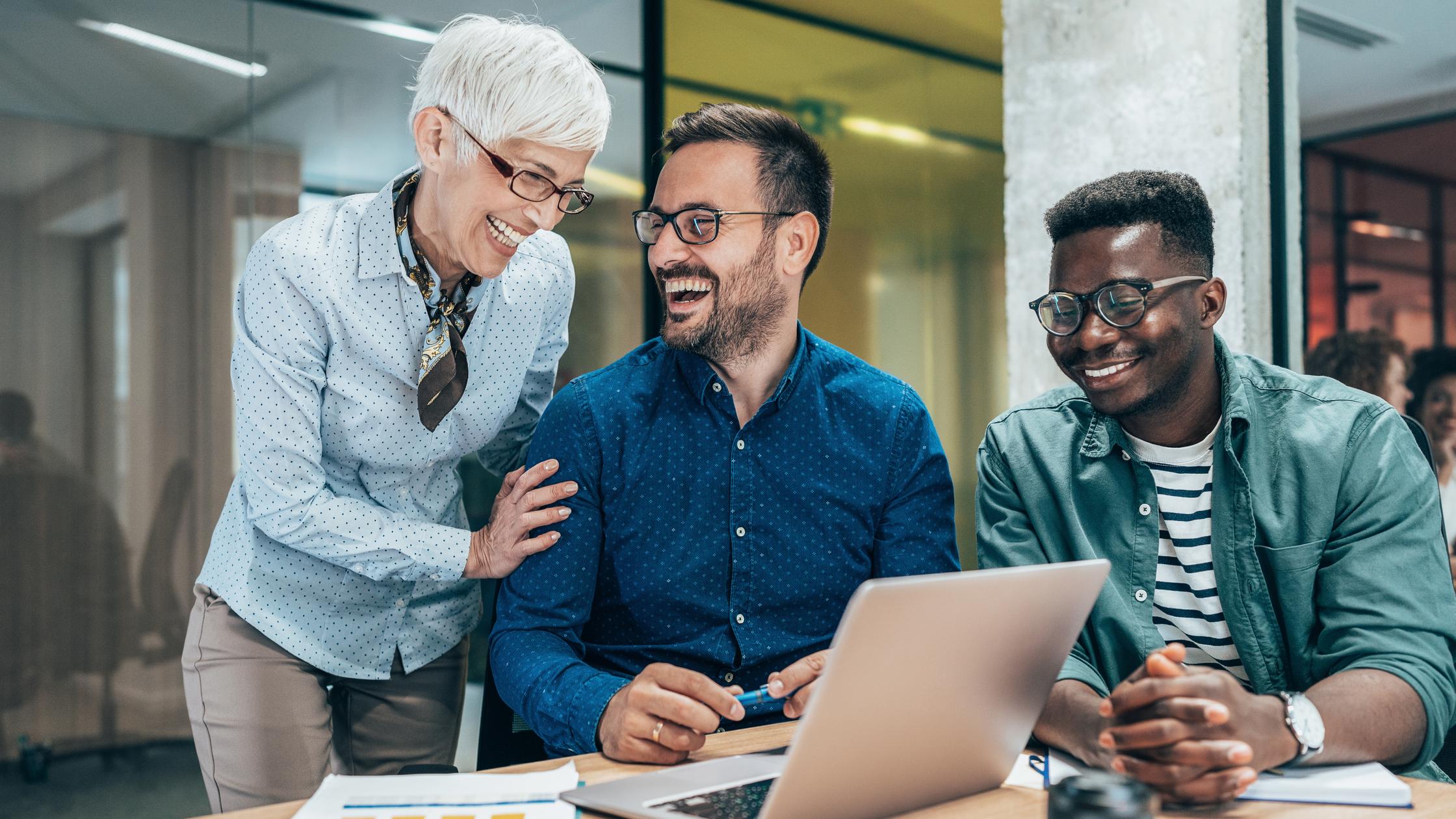 Trois hommes d’affaires de diverses origines se réunissent dans un bureau moderne.