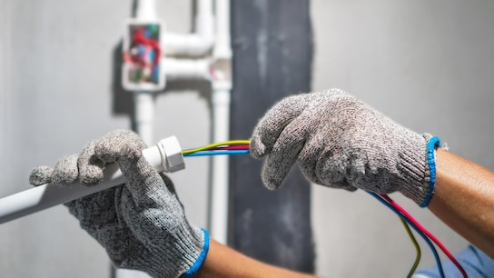 Electrician pulling wire into PVC Conduit.